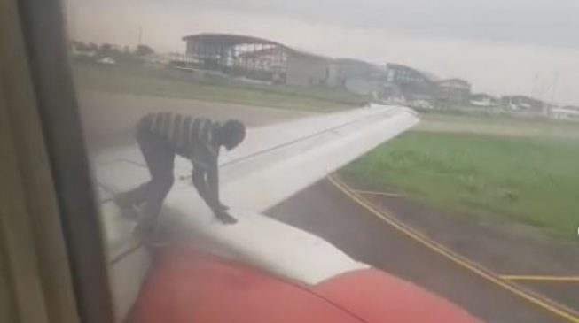 Passengers panic after unidentified man climbs on wings of aircraft prior to take-off
