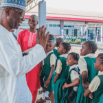 "Adul-Razaq in front of school children"