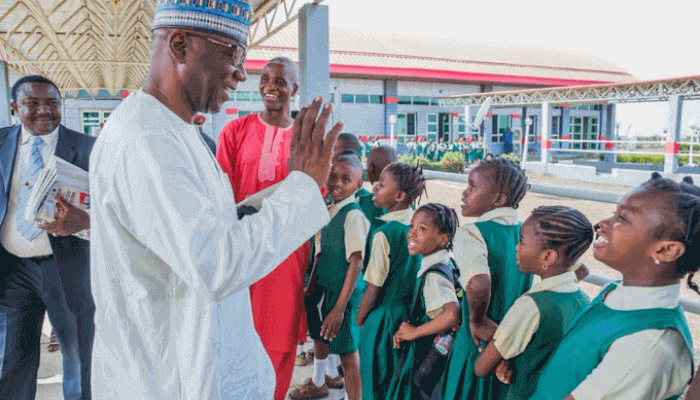 "Adul-Razaq in front of school children"