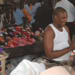 "A seller in front of his goods"