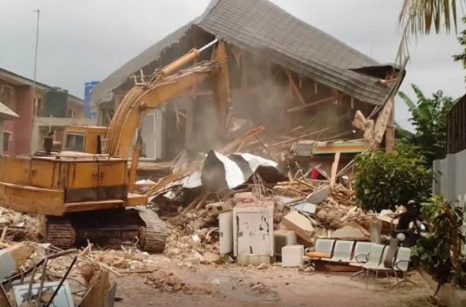 Excavator breaking down a house