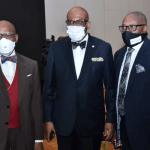 "three men on a suitt wearing a mask"