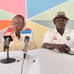 "two officers on a desk giving a speech"