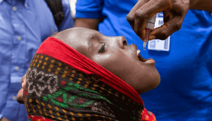"a black girl receiving medicine through her mouth"
