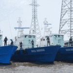 "Three ships by a dock"