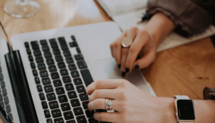 A lady typing a laptop