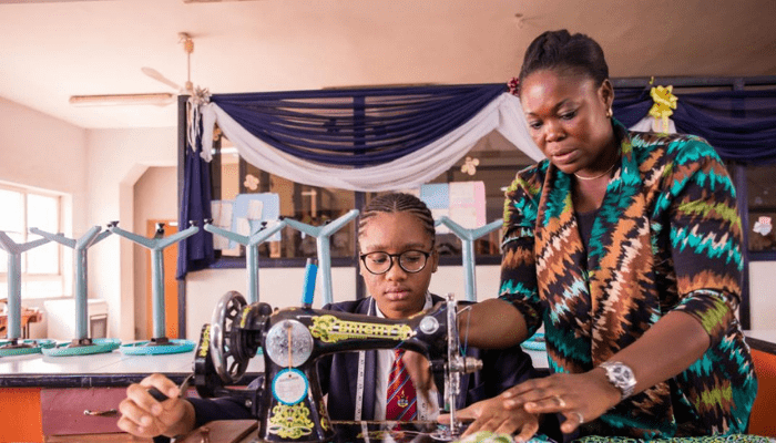 A woman teching a lady how to use a sewing machine