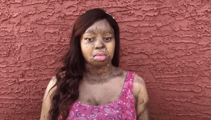 A lady standing by the wall