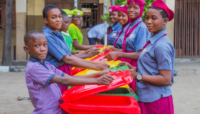 students holding waste bins