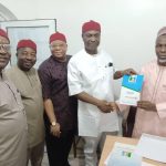 Henry Ikoh (2nd r) brandishing his form, while other party leaders look on.