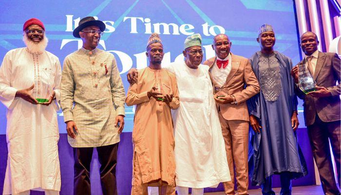 Romeo Oriogun flanked by other winners and some dignitaries at the award night in Lagos