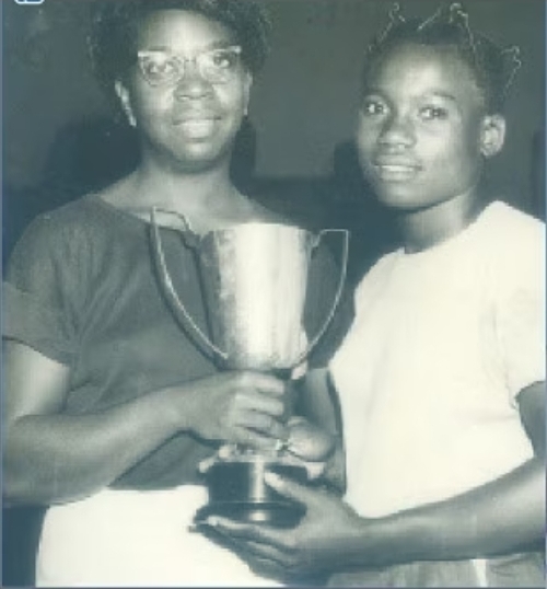 Segun Mabel holding a trophy along with an unnamed lady