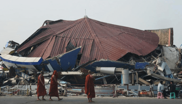 Buddhist monks walk past a collapsed building after a powerful earthquake in Naypyitaw, Myanmar, Saturday, March 29, 2025. (AP Photo/Aung Shine Oo)© The Associated Press