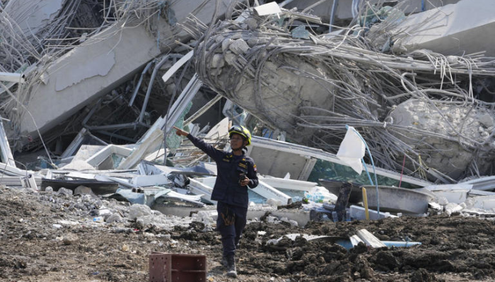 A rescuer gives instruction at the site of an under-construction high-rise building that collapsed on Friday after an earthquake in Bangkok, Thailand, Saturday, March 29, 2025. (AP Photo/Manish Swarup)