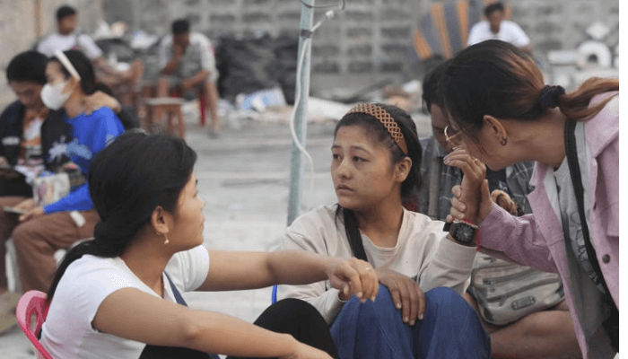 Relatives of workers at a high-rise building under construction that collapsed after a strong earthquake wait as rescuers search for victims, in Bangkok, Thailand, Saturday, March 29, 2025. (AP Photo/Sakchai Lalit)