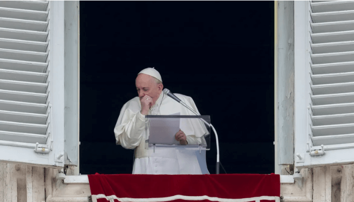 Francis coughs during the Angelus noon prayer he recites from the window of his studio overlooking St Peter's Square at the Vatican on March 1, 2020. [Andrew Medichini/AP Photo]