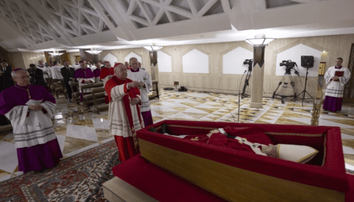 Cardinal Kevin Farrell blesses Pope Francis as he lies in state at the Vatican’s Domus Sanctae Marthae before his transfer to St. Peter’s Basilica for public veneration, Monday, April 21, 2025. Credit: Vatican Media