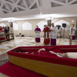 The body of Pope Francis lies in state at the Vatican’s Domus Sanctae Marthae chapel, surrounded by Swiss Guards, cardinals, and Vatican officials paying their respects before his transfer to St. Peter’s Basilica for public veneration, Monday, April 21, 2025. Credit: Vatican Media