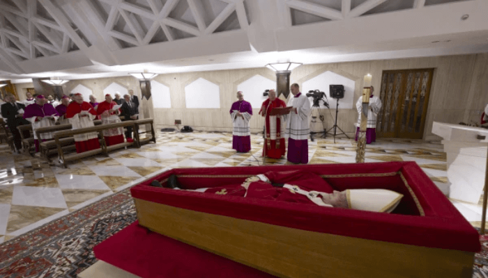 The body of Pope Francis lies in state at the Vatican’s Domus Sanctae Marthae chapel, surrounded by Swiss Guards, cardinals, and Vatican officials paying their respects before his transfer to St. Peter’s Basilica for public veneration, Monday, April 21, 2025. Credit: Vatican Media