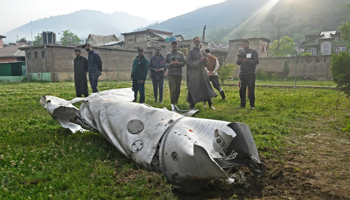 People look at a fuel tank of an aircraft in Wuyan, near Srinagar, on May 7, 2025. India and Pakistan exchanged heavy artillery along their contested frontier on May 7, after New Delhi launched missile strikes on its arch-rival in a major escalation between the nuclear-armed neighbours. New Delhi announced it had carried out “precision strikes at terrorist camps” at nine sites in Pakistan-administered Kashmir, days after it blamed Islamabad for a deadly attack on the Indian-run side of the disputed region. (Photo by Tauseef MUSTAFA / AFP)
